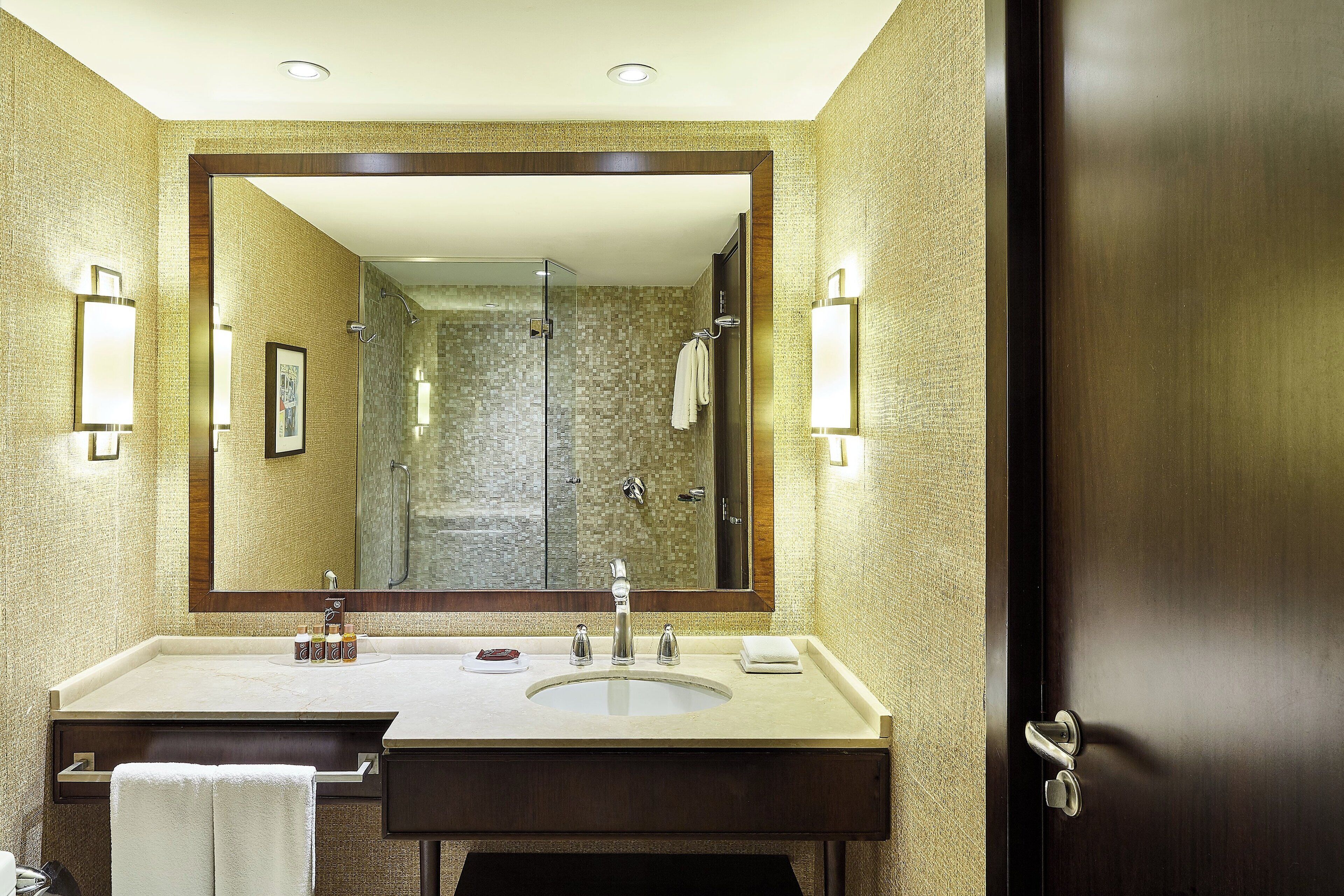 Un baño con un espejo grande, un lavabo y una ducha.