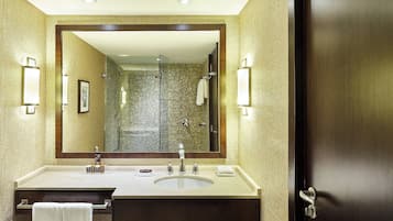 Un baño con un espejo grande, un lavabo y una ducha.
