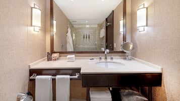 A bathroom with a double sink, a large mirror, and two wall-mounted lights.