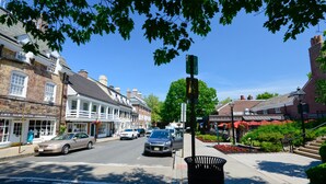 Straßenansicht mit Gebäuden, Autos und blauem Himmel.