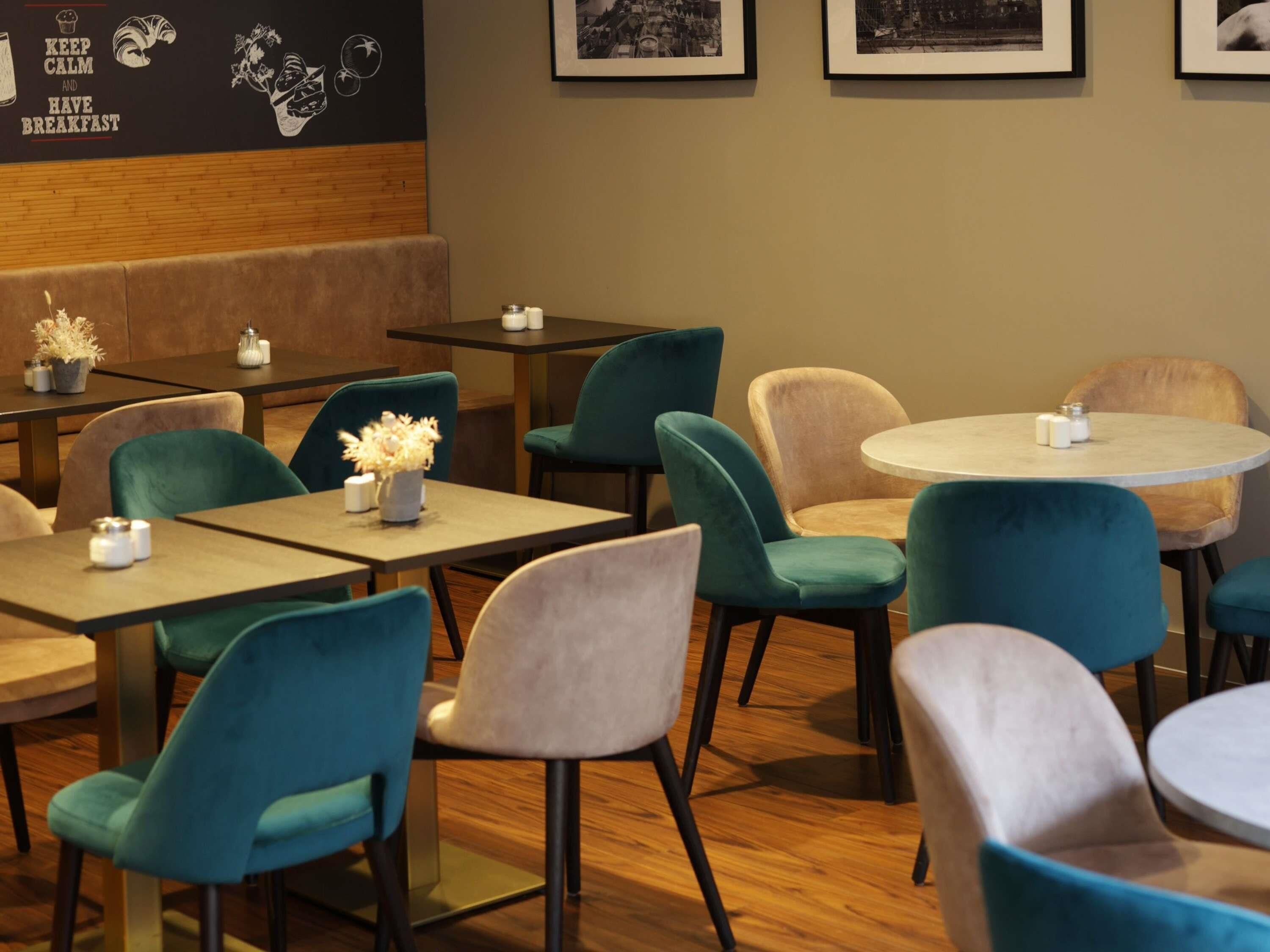 A restaurant with booths and tables, some with flowers.