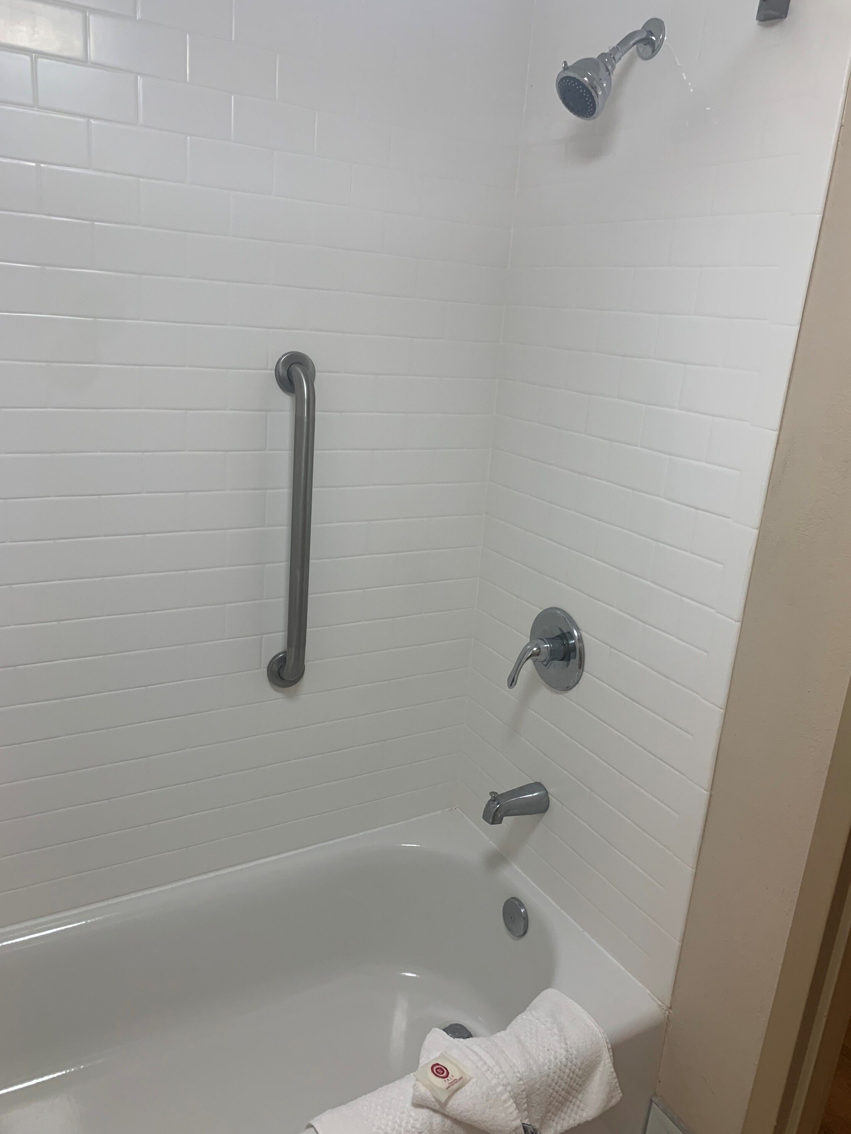 A bathroom with white tiled walls, a white bathtub, a handheld showerhead, a handheld showerhead, a handheld showerhead, a handheld showerhead, a handheld showerhead, a handheld showerhead, a handheld showerhead, a handheld showerhead, a handheld showerhead, a handheld showerhead, a handheld showerhead, a handheld showerhead, a handheld showerhead, a handheld showerhead, a handheld showerhead, a handheld showerhead, a handheld showerhead, a handheld showerhead, a handheld showerhead, a handheld showerhead, a handheld showerhead, a handheld showerhead, a handheld showerhead, a handheld showerhead, a handheld showerhead, a handheld showerhead, a handheld showerhead, a handheld showerhead, a handheld showerhead, a handheld showerhead, a handheld showerhead, a handheld showerhead, a handheld showerhead, a handheld showerhead, a handheld showerhead, a handheld showerhead, a handheld showerhead, a