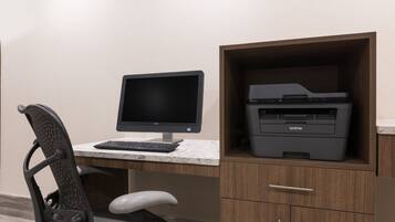 A workspace with a Dell monitor, Brother printer, and a white office chair.