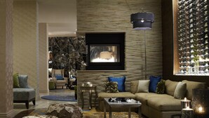 A modern living room with a fireplace, a wall-mounted TV, and a wine rack. - Renaissance Asheville Downtown Hotel (Asheville)