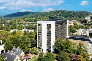 A multi-story building with a modern design, surrounded by trees and a hilly landscape. - Renaissance Asheville Downtown Hotel (Asheville)
