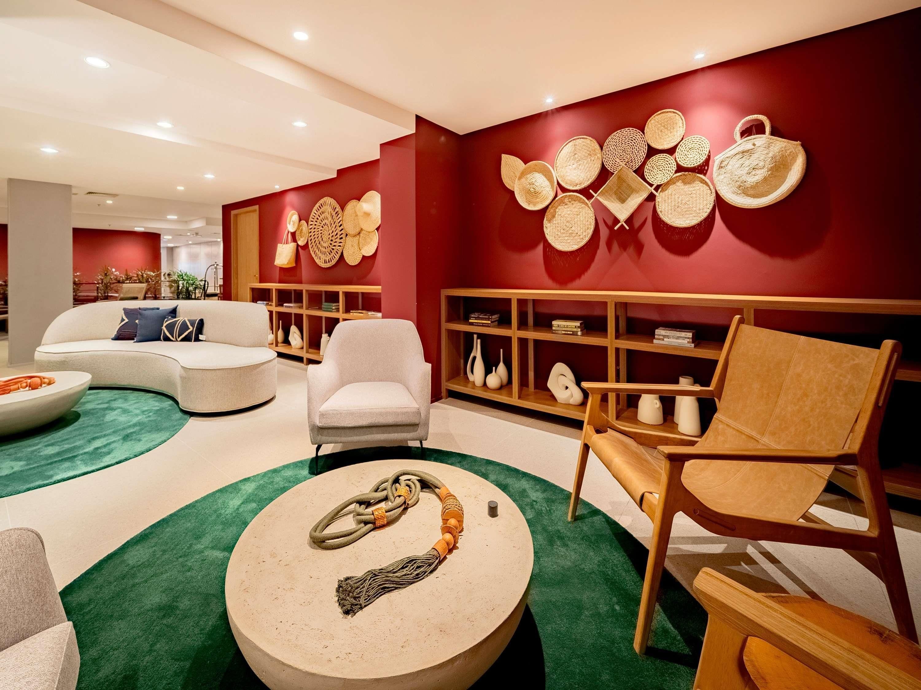 A modern living room with a sofa, armchairs, a coffee table, and a bookshelf.