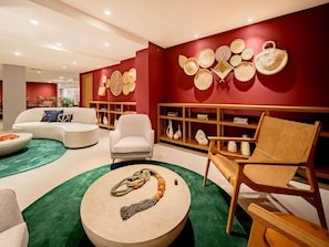 Een moderne woonkamer met een bank, fauteuils, een salontafel en een boekenkast.