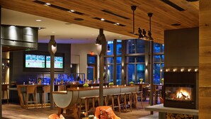 Un interior moderno con una zona de bar, asientos y una chimenea.