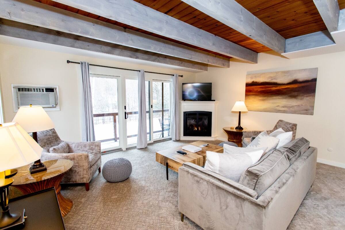 A living room with a fireplace, a sofa, a coffee table, and a television.