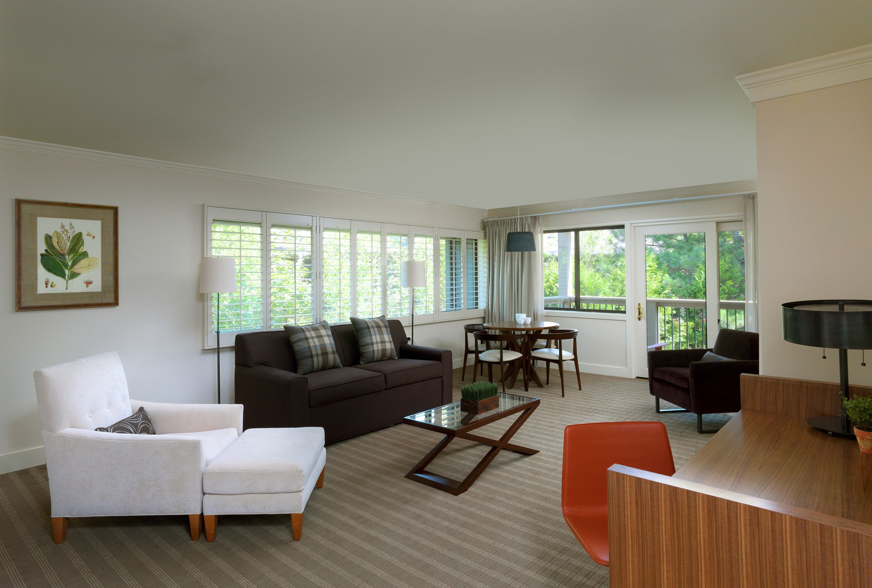 A living room with a sofa, armchair, coffee table, and a dining area with a table and chairs.