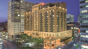 A multi-story hotel with a prominent entrance and a large parking area.