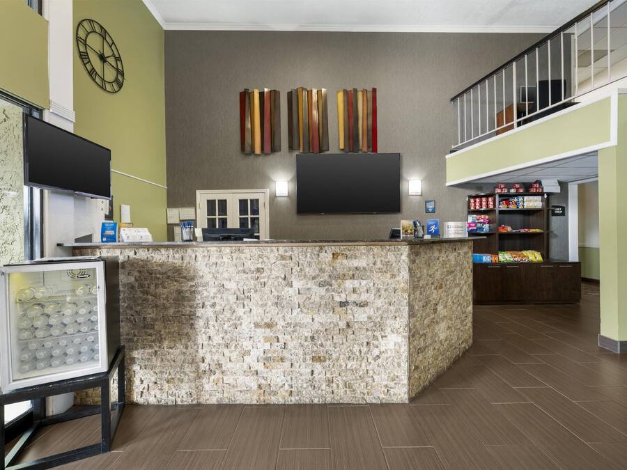 A reception area with a stone counter, a clock, and a flat-screen TV.
