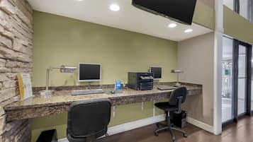 A reception desk with a stone accent wall, a flat-screen monitor, a printer, and a computer.