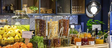 A buffet with various food items, including fruits, nuts, and condiments.