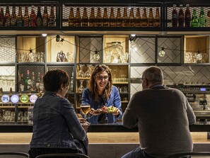 A bar with a counter, shelves with bottles, and glasses. - ibis Nanterre la Défense (Nanterre)