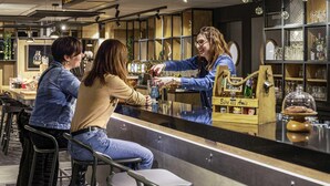A bar area with stools, a counter, and shelves with glassware. - ibis Nanterre la Défense (Nanterre)