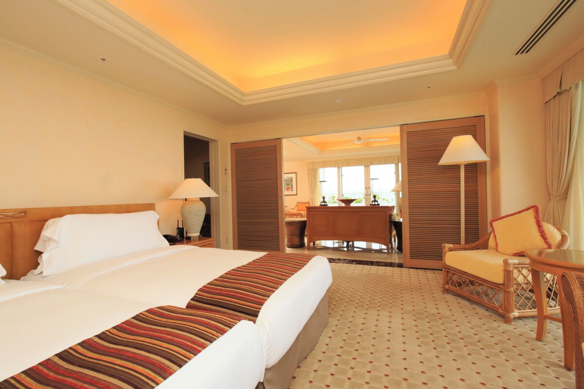 Een hotelkamer met een groot bed, een bureau, een stoel en uitzicht op de eetruimte.