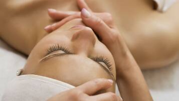 A person lying down with hands on their abdomen, possibly receiving a massage.