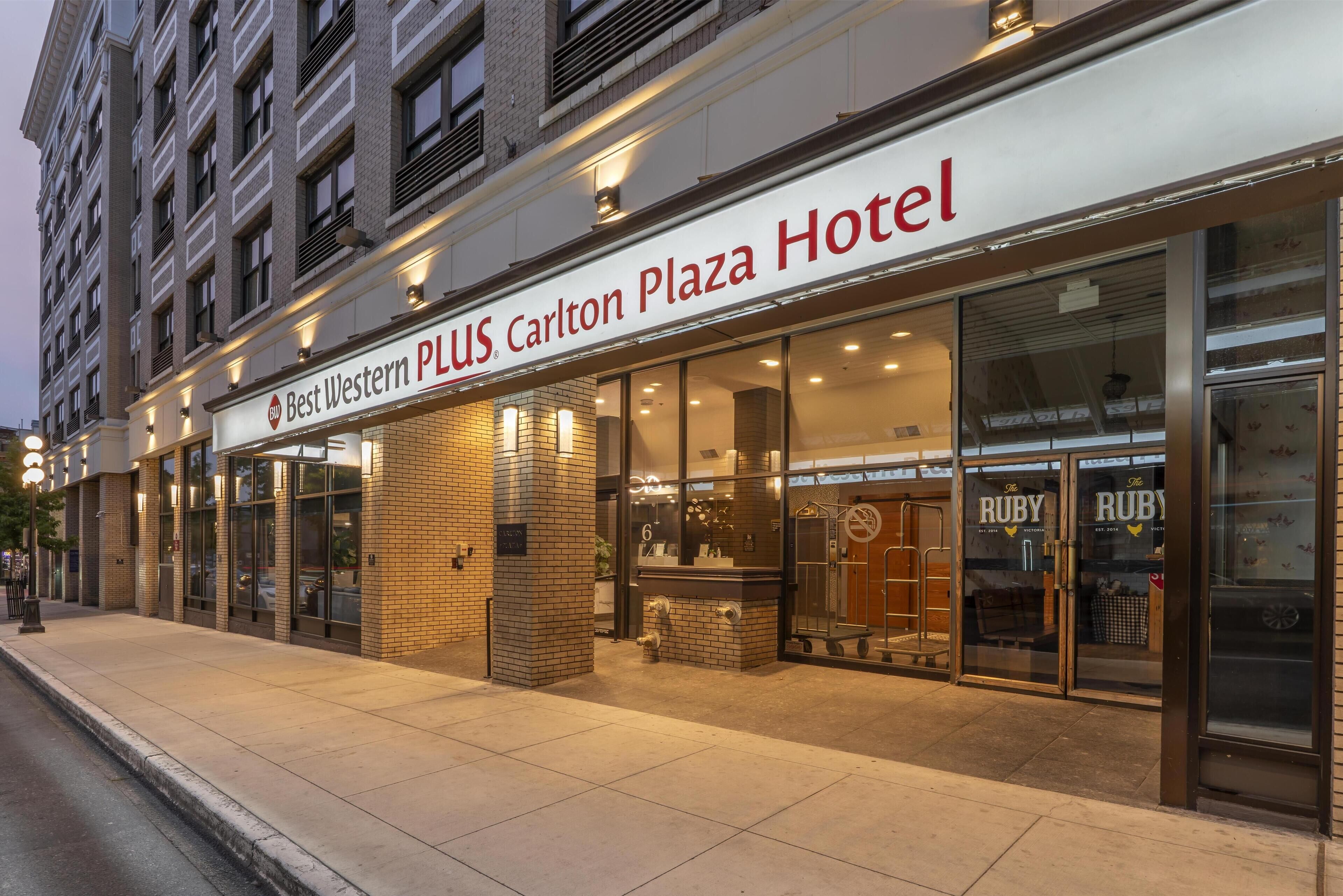 A hotel exterior with a prominent sign for the Carlton Plaza Hotel.