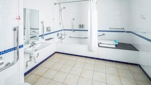 A modern bathroom with a walk-in shower, a sink, and a bathtub.