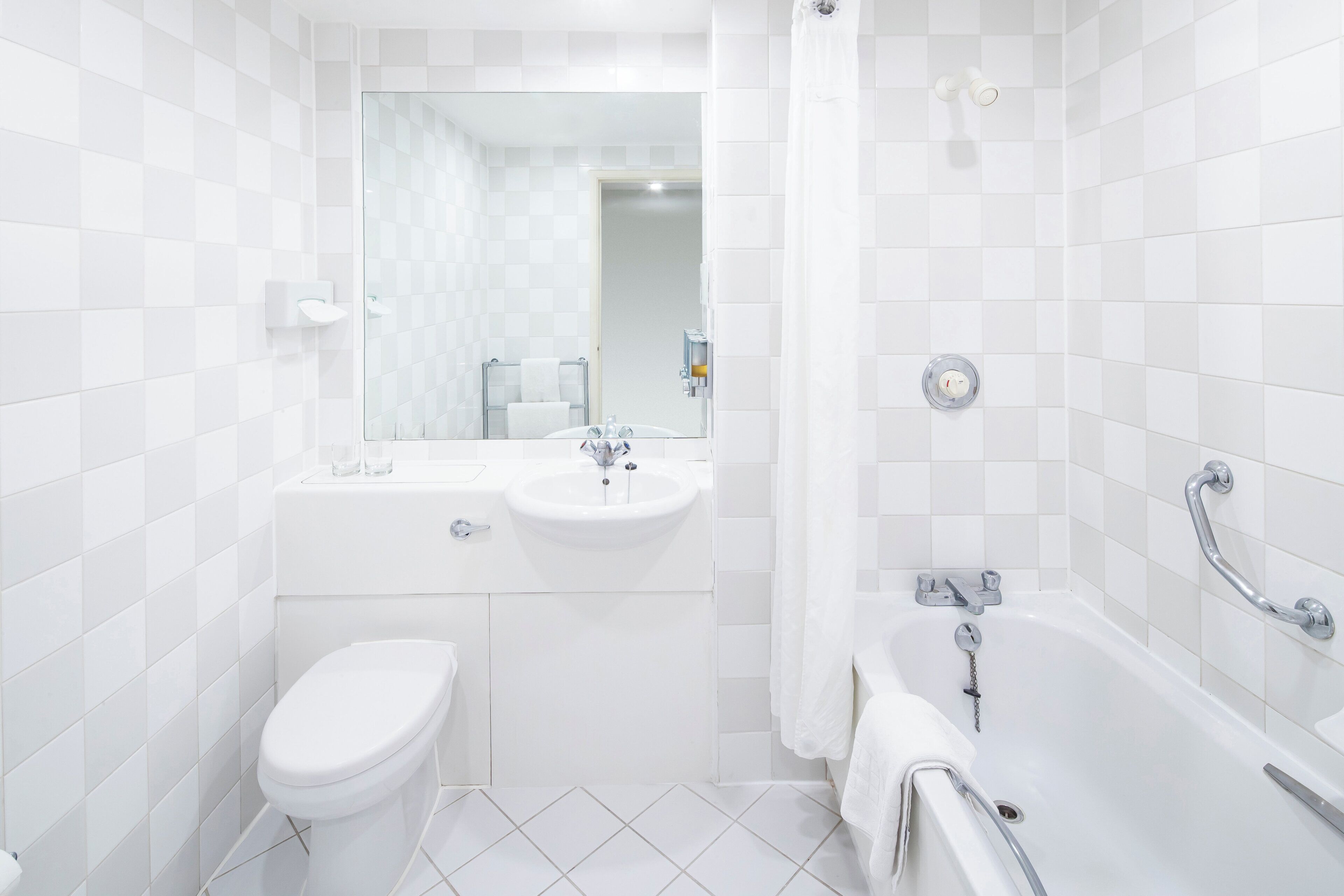 Un baño moderno con inodoro, lavamanos y bañera.