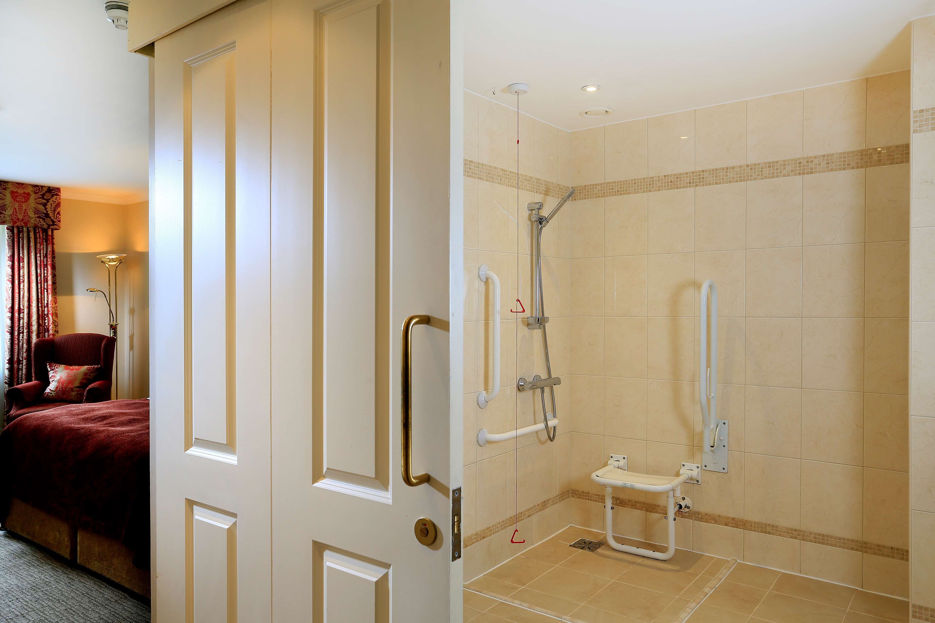 A hotel room with a bed, a bathroom with a shower, and a toilet.
