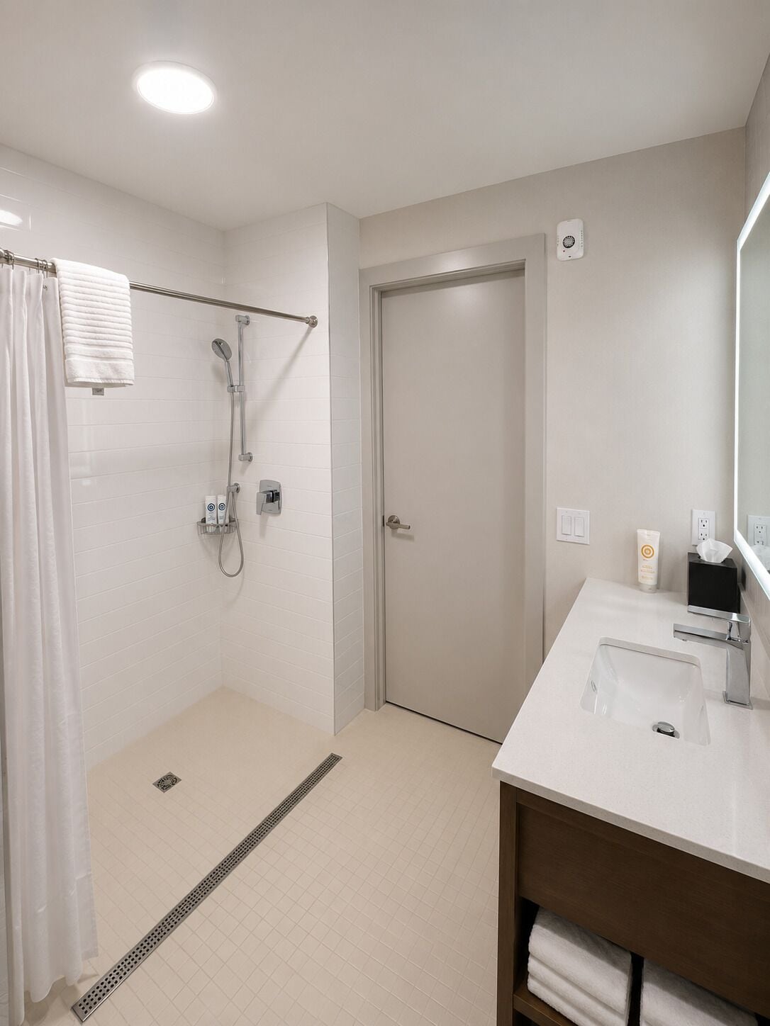 A modern bathroom with a shower, toilet, and sink.