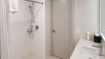 A modern bathroom with a shower, toilet, and sink.