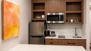 Una cocina moderna con una isla central, electrodomésticos de acero inoxidable y muebles de madera.