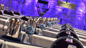 A row of tables with crystal glasses and silver pitchers, likely for a formal event.