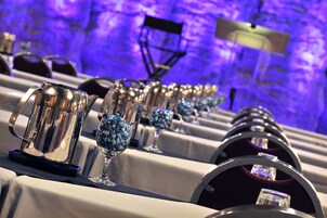 A row of tables with crystal glasses and silver pitchers, likely for a formal event.