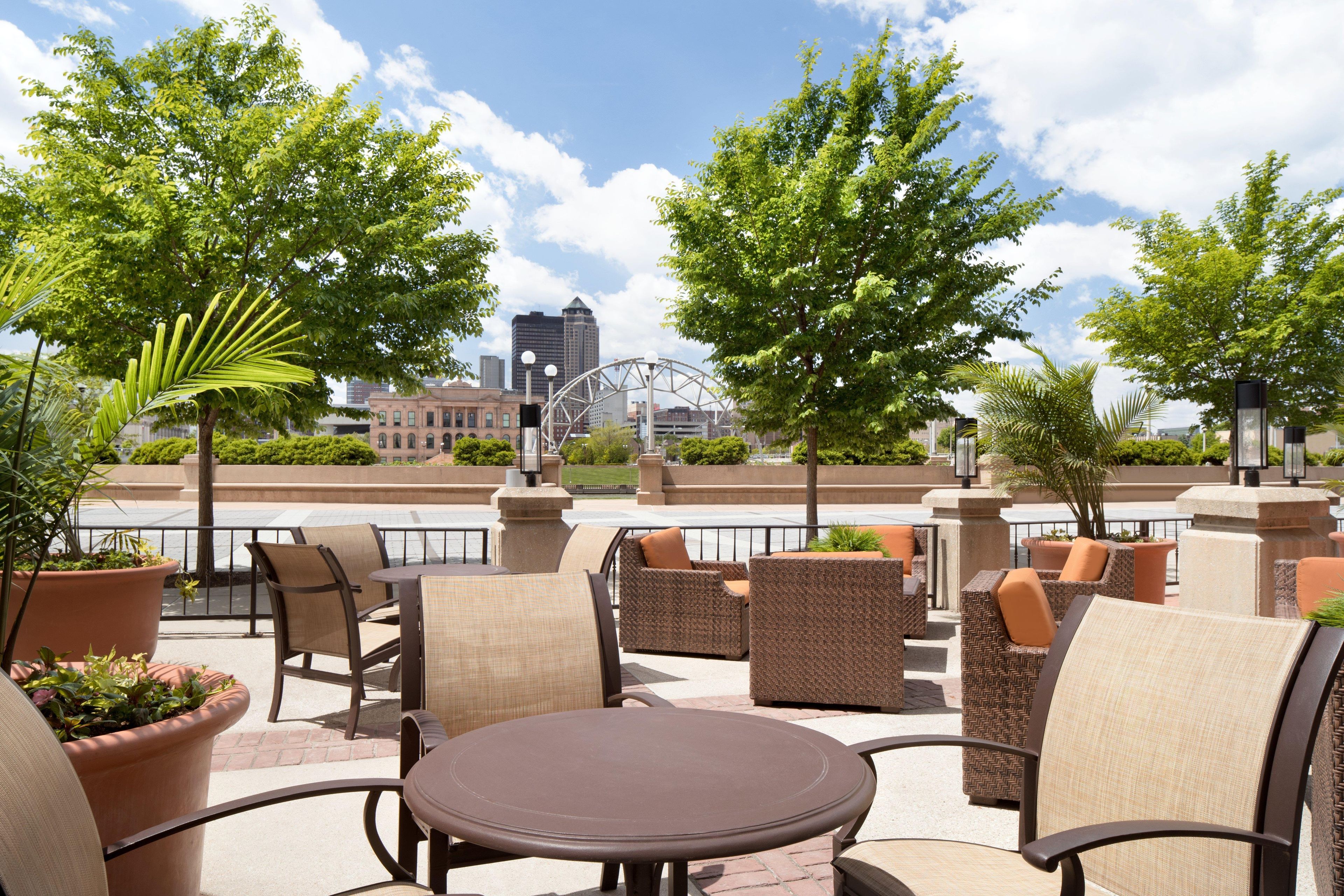 An outdoor seating area with wicker furniture and potted plants.