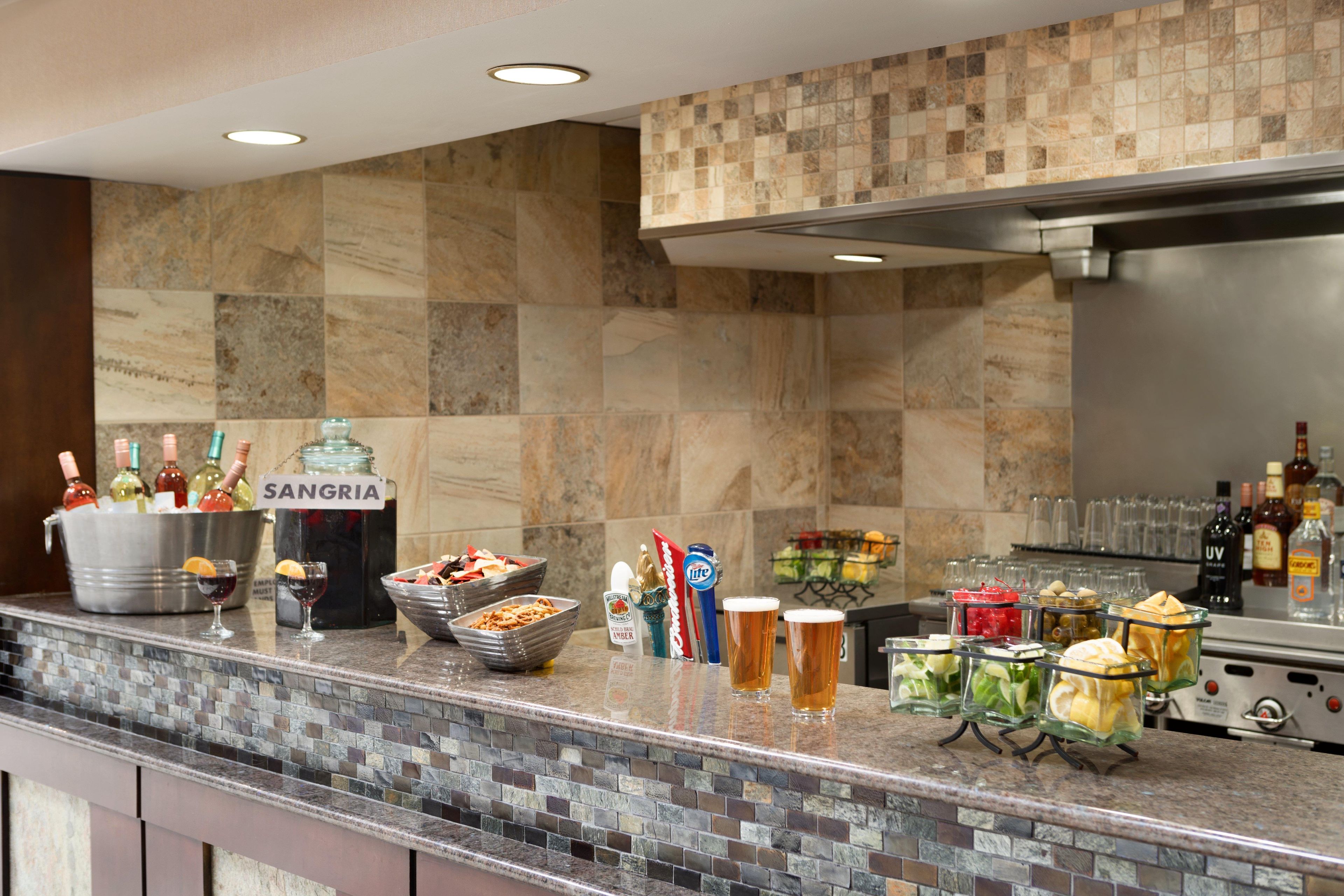 A bar area with a variety of beverages, including sangria, beer, and cocktails, and a selection of snacks.