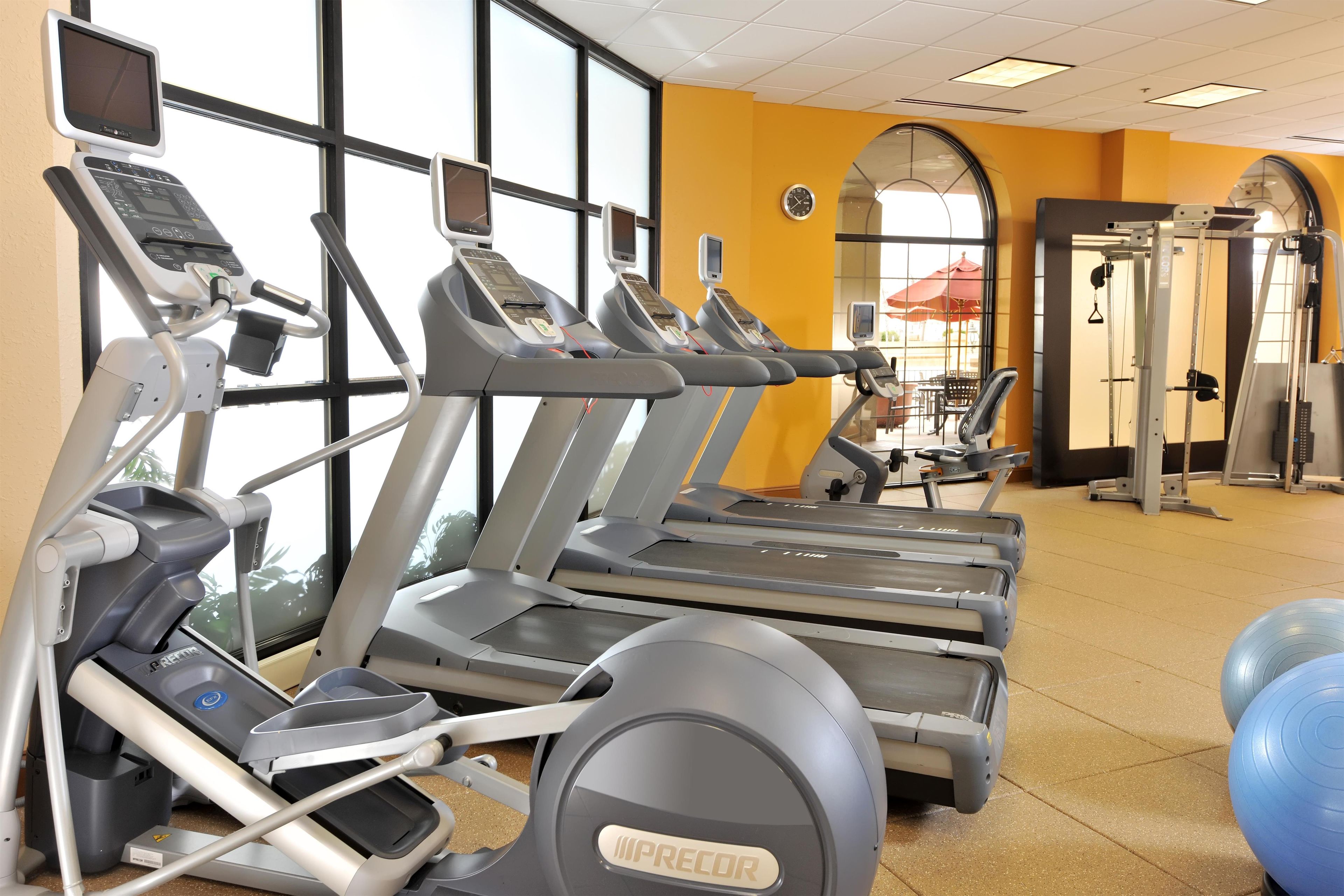 A gym with multiple treadmills, exercise balls, and weight machines.