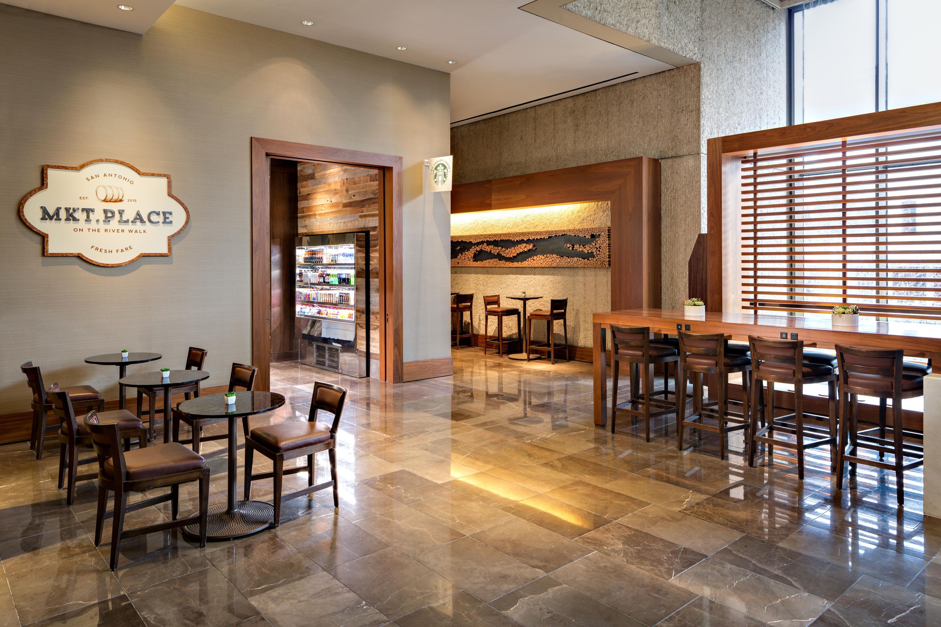 A restaurant area with tables and chairs, a bar, and a wall sign.
