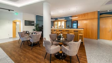 Un lobby moderno con una zona de bar, asientos y una recepción.