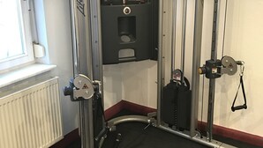 A gym with a cable machine, weight stack, and a pull-up bar. - Andante Hotel Dresden (Dresden)