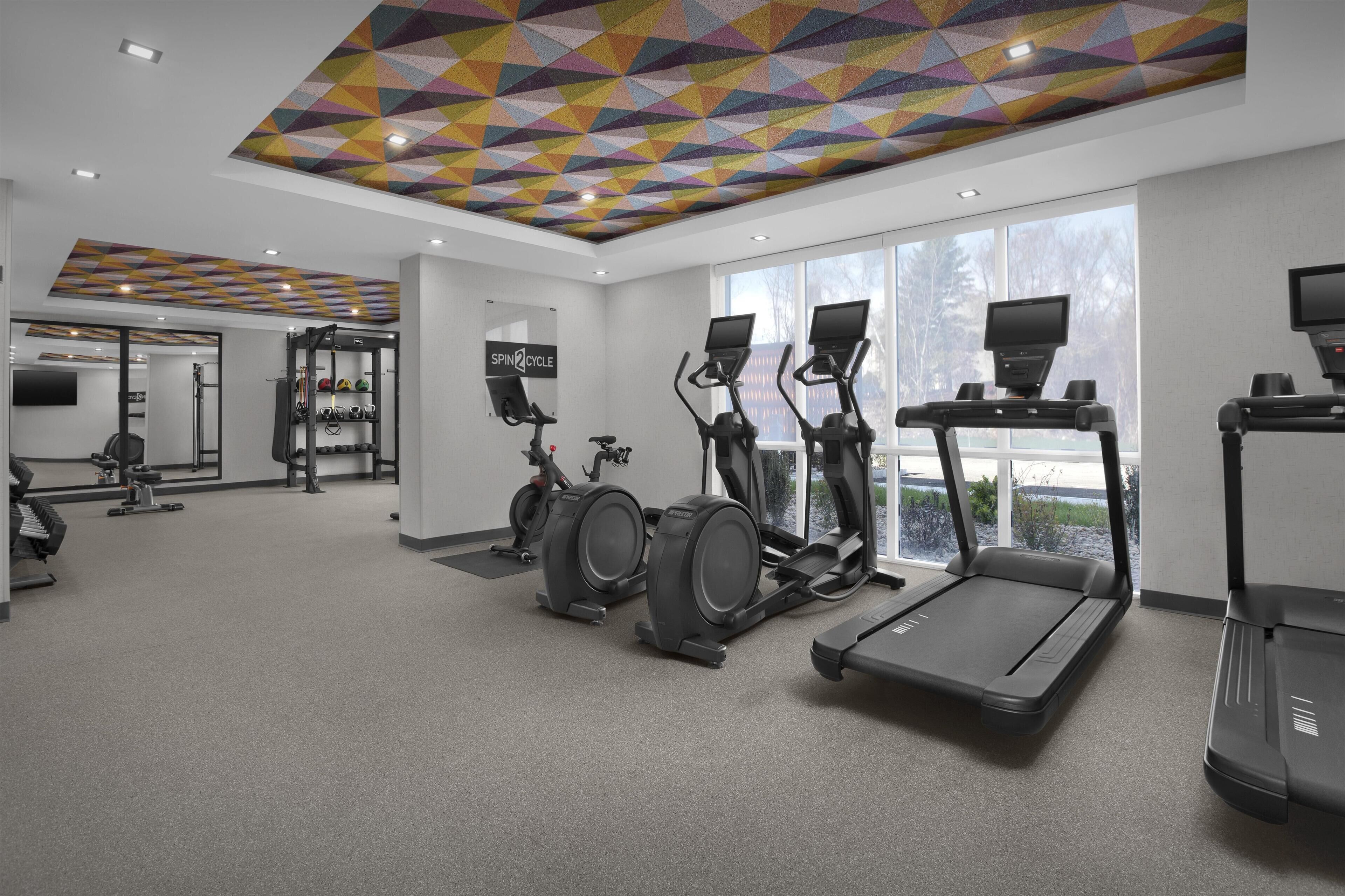 A gym with treadmills, elliptical machines, and a stationary bike.