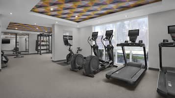A gym with treadmills, elliptical machines, and a stationary bike.