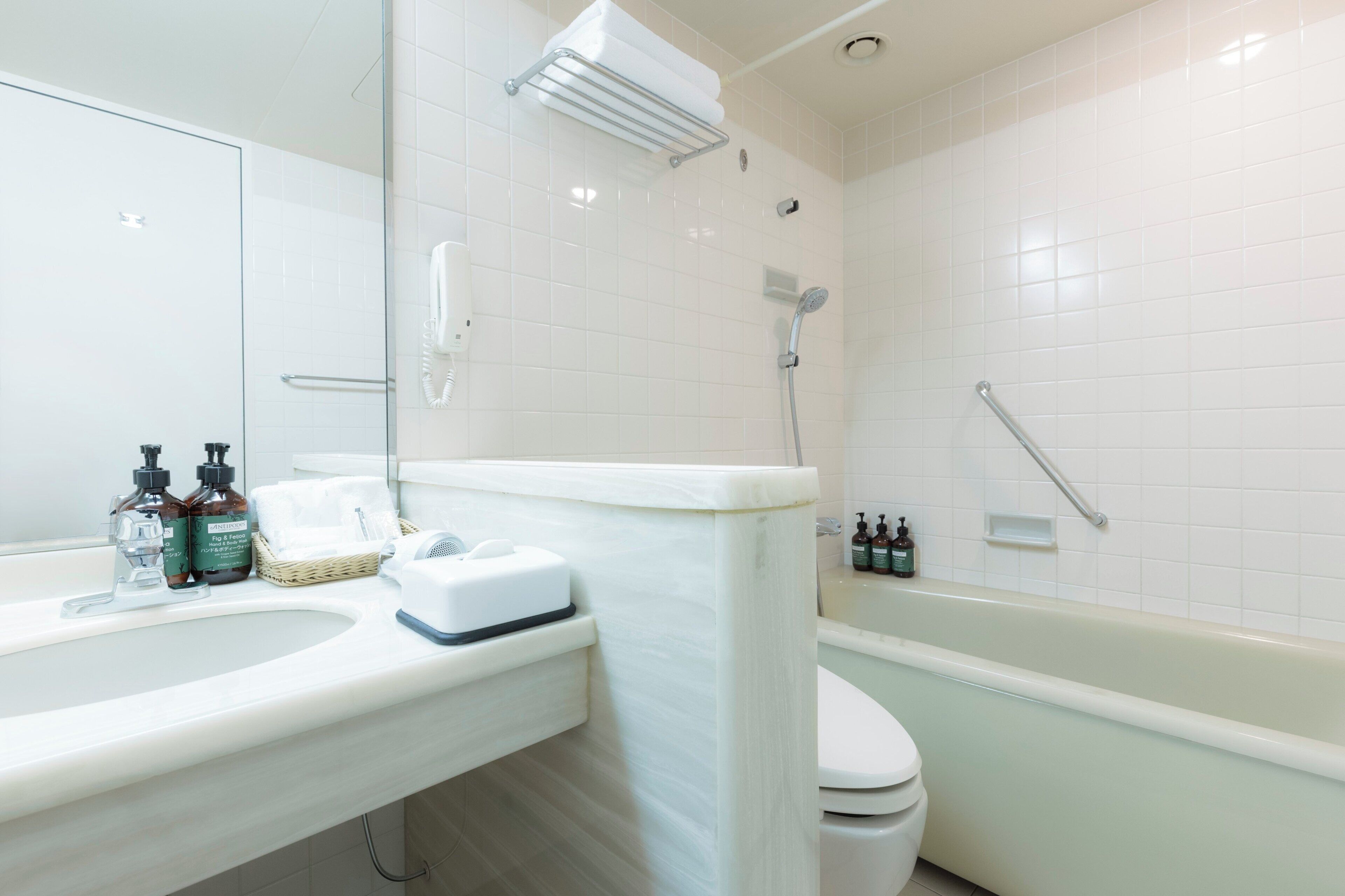 A bathroom with a white sink, a toilet, and a bathtub.