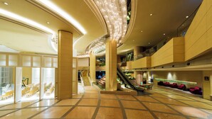 A spacious lobby with a central staircase, seating areas, and a modern design.