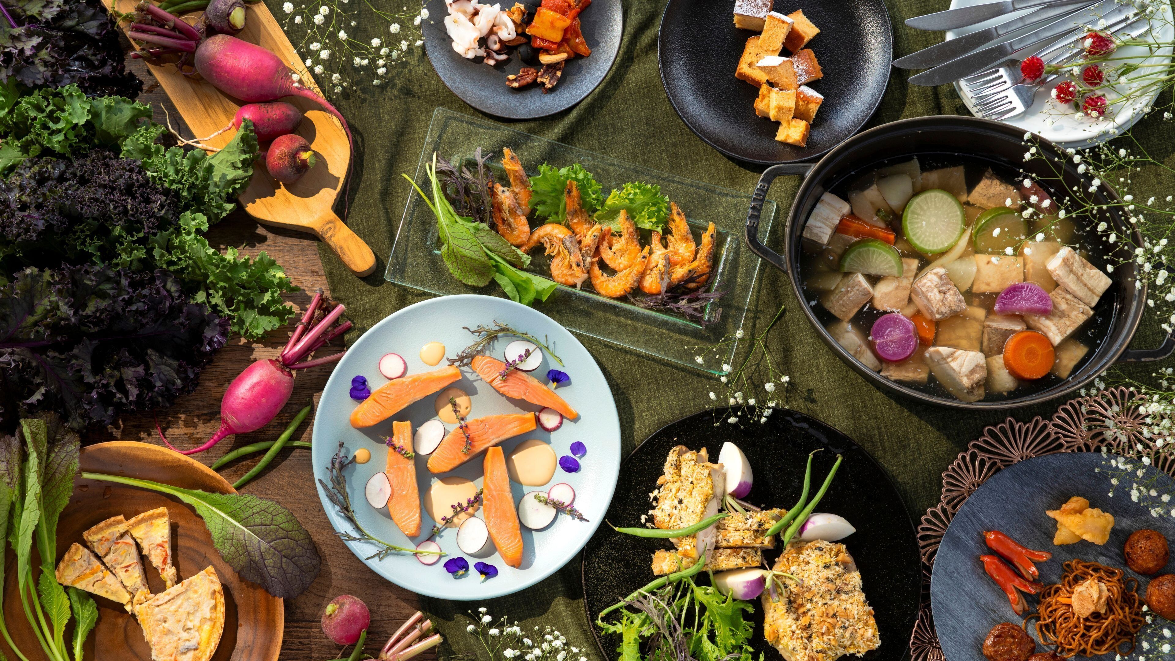 Una variedad de platos y verduras sobre una mesa.