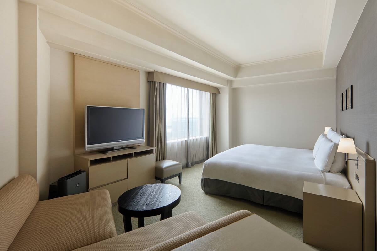 Une chambre d’hôtel équipée d’un lit, d’une télévision, d’un bureau et d’une chaise.