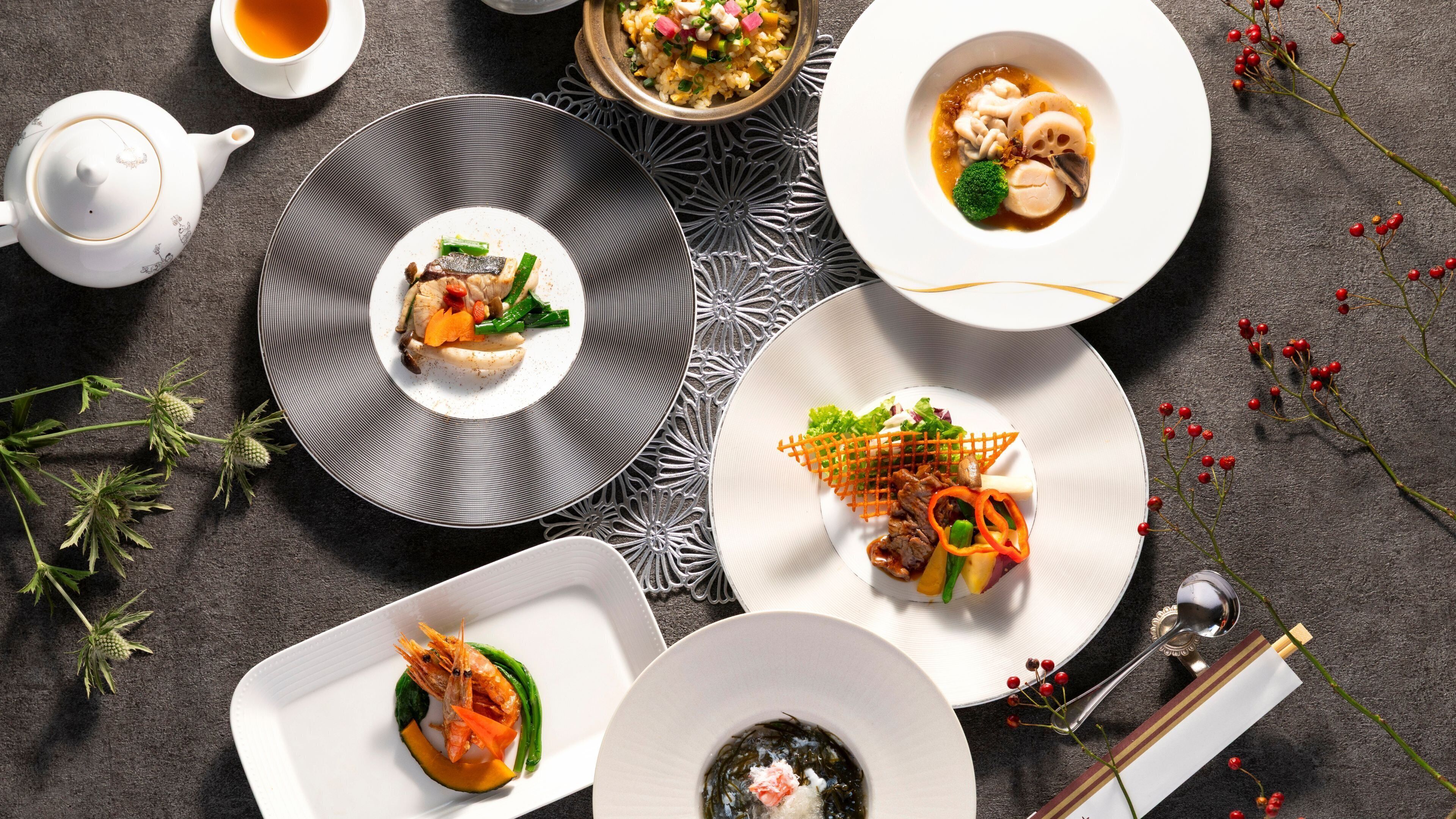 A table with various dishes, a teapot, and some decorative elements.