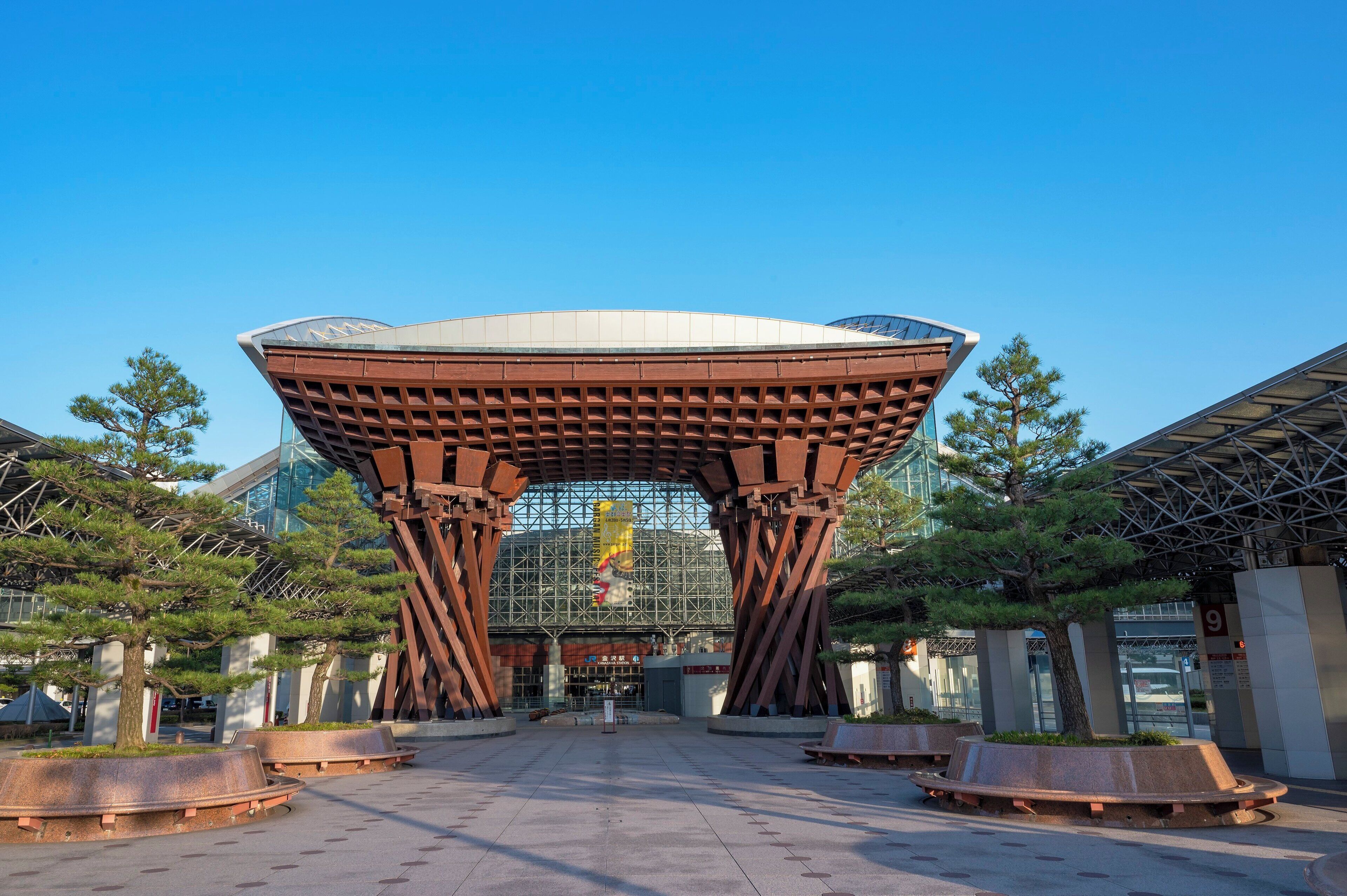 A modern building with a unique architectural design, featuring a large central structure supported by multiple pillars.