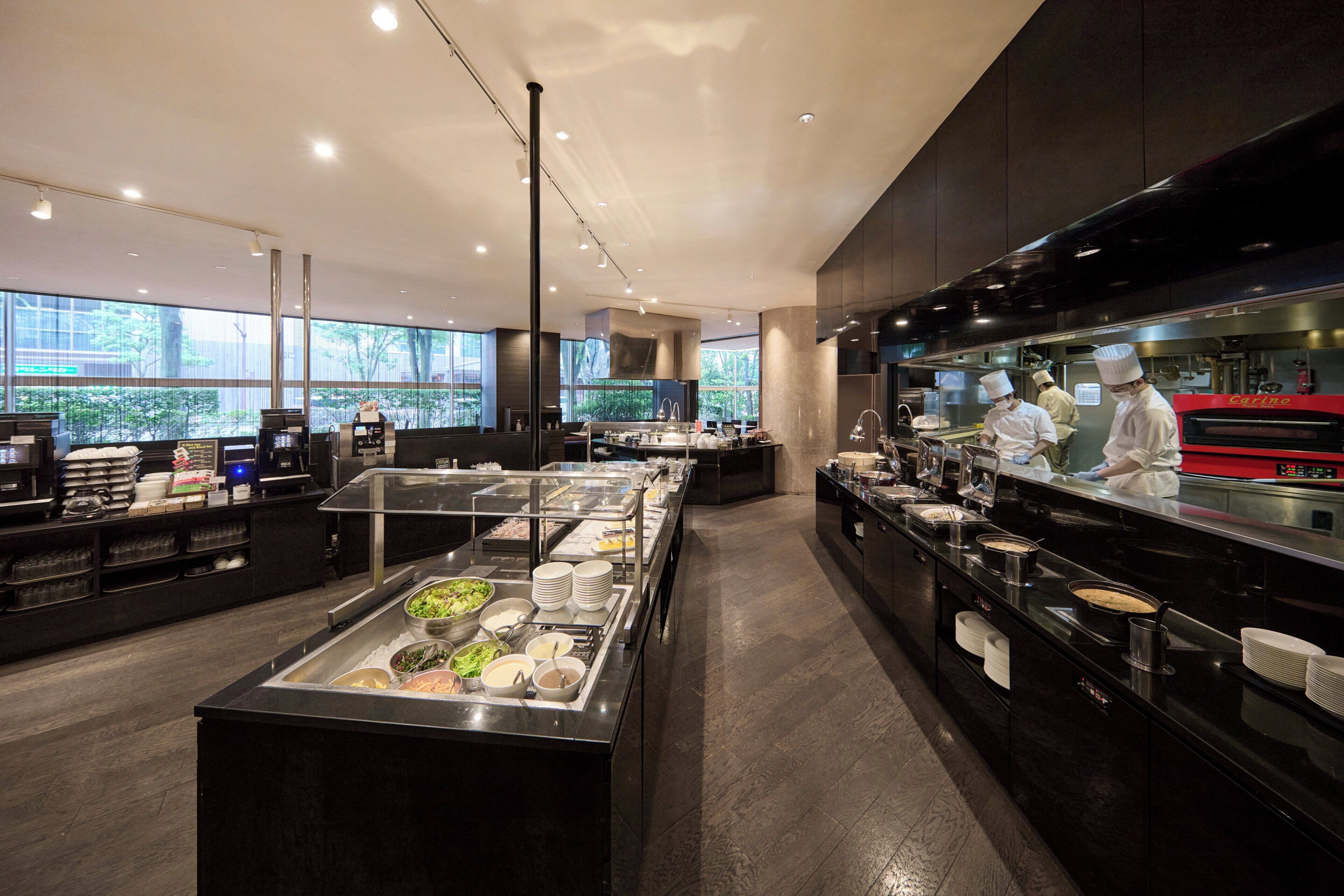 Una cocina moderna con chefs, una zona de bufé y vistas a través de amplios ventanales.