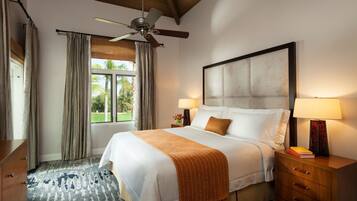 A hotel room with a bed, bedside lamps, a nightstand, a wooden dresser, a ceiling fan, and a window with curtains.