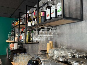 A bar area with shelves of liquor bottles and glasses. - ibis Pau Centre (Pau)