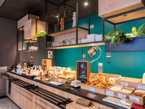 Un bufé de desayuno con diversos alimentos y un letrero para la cafetería 'HOT THING'.