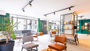 Un espace détente moderne avec des sièges, une table basse et une bibliothèque.